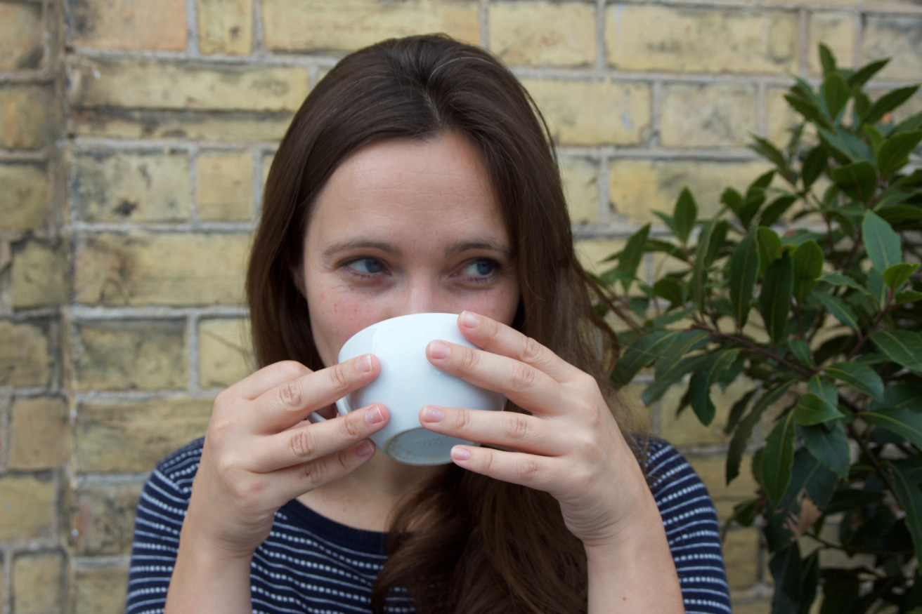 Emma drinking coffee and smiling