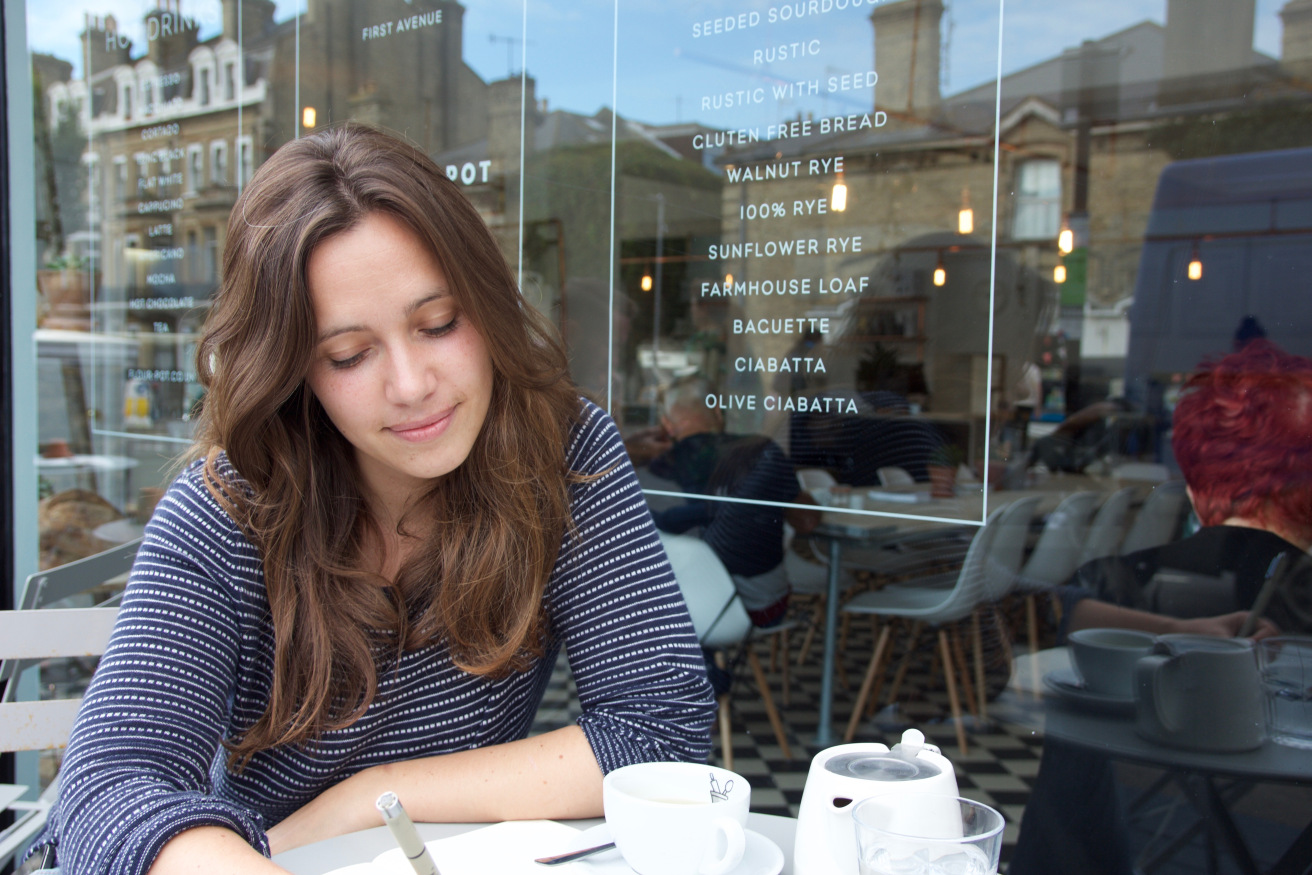 Emma at a cafe, taking notes